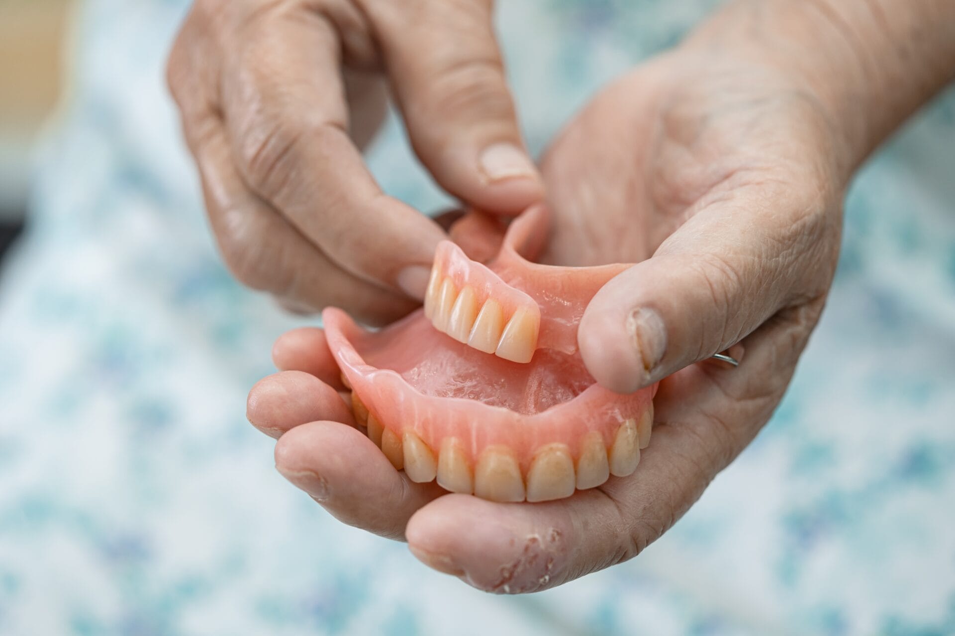 Asian senior or elderly old woman patient holding to use denture in nursing hospital ward, healthy strong medical concept